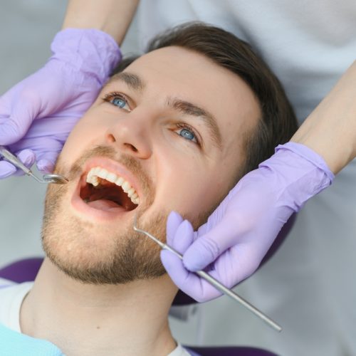 Periodontal,Services.,Closeup,Shot,Of,Smiling,Man,Getting,Treatment,In